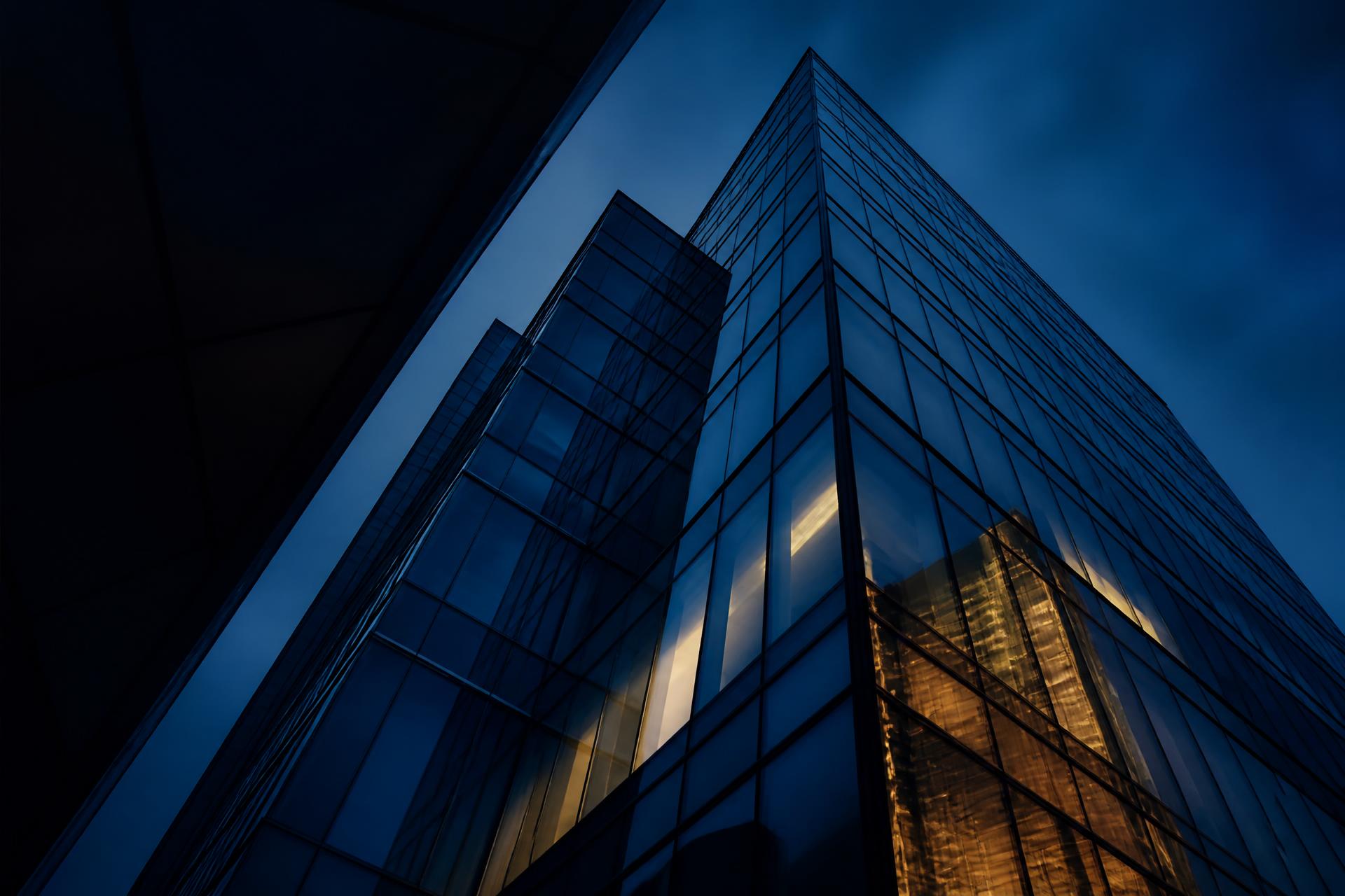 Torre corporativa de vidro ao anoitecer